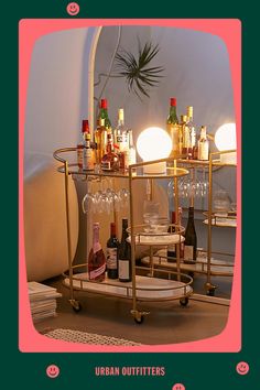 a bar cart with wine glasses and bottles on it in front of a mirror that says urban outfitters