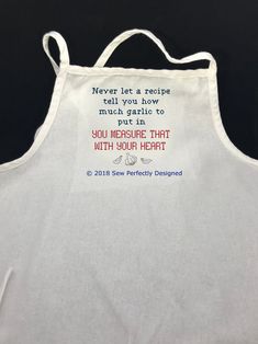 a white apron with an embroidered message on the front that says, never let a recipe roll you how to put it in