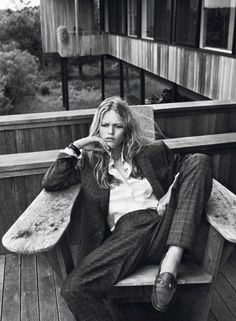 a woman sitting on top of a wooden bench