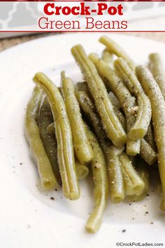 some green beans on a white plate with seasoning sprinkled over them and the words crock - pot green beans