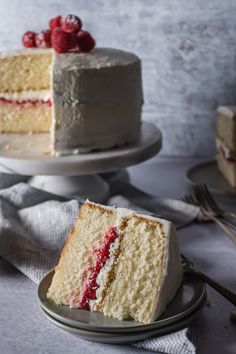 a slice of cake with white frosting and raspberries on top