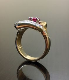 DeKara Designs Classic Beautiful Art Deco Ruby and Diamond Ring Handmade. Metal- 14K Yellow Gold, .583 Stones- 1 Natural Round Ruby 0.85 carats, 6 Round Diamonds, G-H Color SI1-SI2 Clarity .32 carats. Art Deco Inspired 14K Yellow Gold Ruby Diamond Engagement Ring. There is a beautiful six prong set round ruby that is set in a 14K White Gold setting to bring out the color of the ruby. The bottom of the the ring (or the top depending which side you wear the ring) has six round pave set diamonds. T Gold Ruby Ring With Tension Setting For Formal Occasions, Polished Ruby Ring With Diamond In Round Cut, Yellow Gold Ruby Ring With Polished Round Cut, Exquisite Yellow Gold Ruby Wedding Ring, Exquisite Yellow Gold Ruby Ring For Wedding, Gold Ruby Wedding Ring 14k, Exquisite Gold Marquise Cut Ring, Exquisite Gold Ring With Marquise Cut, Gold Ruby Ring With Diamond Cut