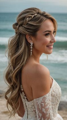 a beautiful woman with long hair standing on the beach wearing a white dress and earrings