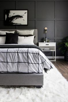 a bedroom with black and white decor on the walls, carpeted floor and bed