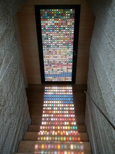 the stairs are covered with many colored glass tiles and there is a large window in the center