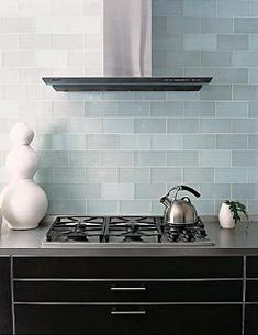 a stove top oven sitting inside of a kitchen next to a wall mounted range hood