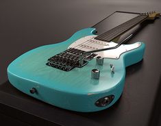 a blue electric guitar sitting on top of a table