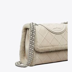 Enduring glamour. The Fleming Soft Shearling Shoulder Bag is made of the softest leather with diamond pattern pintucks, sealed with a bombé Double T. Braided with brushed chain, the strap can be worn doubled over the shoulder or long and crossbody. Tory Burch Fleming Convertible Shoulder Bag, Kira Chevron, Winter Bags, Barrel Bag, Womens Designer Handbags, Tory Burch Bags, Designer Shoulder Bags, Tory Burch Bag, Gorgeous Bags