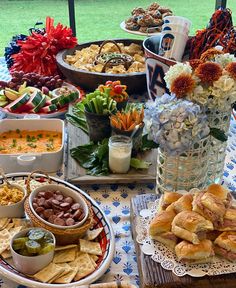 a table filled with lots of food on top of a blue and white table cloth