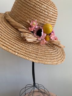 "This is a vintage 1950's straw sun hat. The hat is intricately woven with a braided section across the brim. There is also pink tone faux floral details. By the faux flowers there are also plastic faux fruit adding a pop of color and texture. The hat is in excellent condition. Measurements: Circumference: 21\" | Inside Depth: 5.5\" | Brim Depth: 4\" | Brim Circumference: 46\" Unless otherwise stated all vintage items are used and may have minor to moderate wear or discoloration considering the Vintage Sun Hat, Vintage Short Brim Sun Hat For Garden Party, Pink Bohemian Sun Hat For Garden Party, Bohemian Pink Sun Hat For Garden Party, Vintage Straw Hat With Short Brim For Beach, Vintage Fedora Straw Hat For Garden Party, Vintage Mini Hats With Flat Brim For Beach, Vintage Mini Hat With Flat Brim For Beach, Vintage Sun Hat For Kentucky Derby Vacation