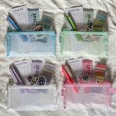 three clear plastic containers with pens and pencils in them on a white sheeted surface