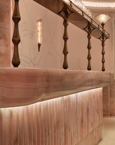 the lights are on above the counter in the room that is decorated with pink marble