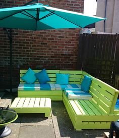 a green couch sitting next to a blue umbrella