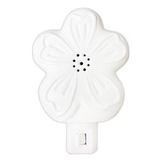 a white wall light with a flower shaped design on it's side and black dots in the center