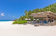 an empty beach with umbrellas and tables on it