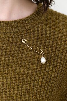 The Pearl Safety Pin Brooch is a stunning accessory that marries contemporary design with timeless beauty. This brooch showcases a lustrous freshwater pearl gracefully suspended from a large safety pin, offering a unique twist to your hairstyles or outfits. Perfect for those who appreciate a touch of sophistication, this brooch adds a radiant shimmer to any look. Safety Pin Accessories, Elegant Safety Pin Brooch, Wedding Brooch In Safety Pin Shape, Brooch Styling, Brooch Aesthetic, Large Safety Pin, Safety Pin Brooch, Tassel Scarf, The Pearl