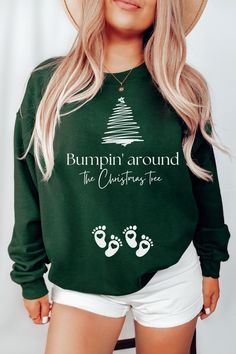 a woman wearing a green sweatshirt that says bumpin'around the christmas tree