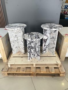 three marble pedestals sitting on top of wooden pallets