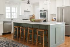 a kitchen island with stools in front of it