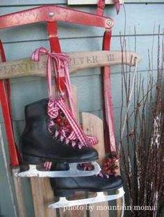 a pair of ice skates sitting on top of a sled next to flowers