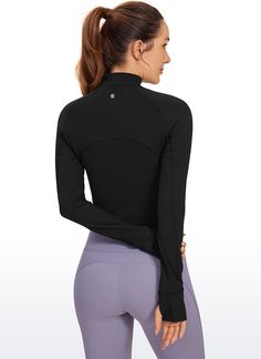 the back view of a woman in black top and leggings with her hands on her hips