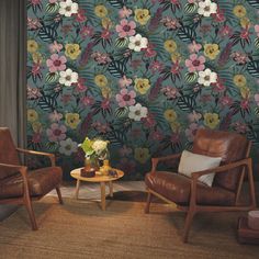 two chairs and a table in front of a floral wallpaper