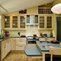 a kitchen with wooden cabinets and blue counter tops on the island in front of the sink