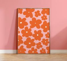 an orange and pink flowered wall hanging on the side of a room with hardwood floors