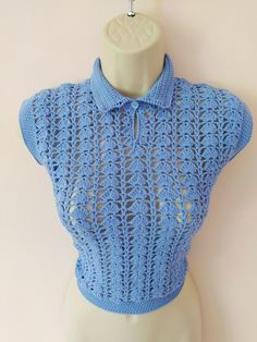 a mannequin wearing a blue crochet shirt on top of a white dummy