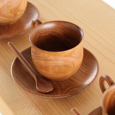 three wooden bowls and spoons on a table