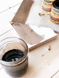 some paint is sitting on top of a table next to an open tin can and brush