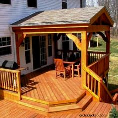 a wooden deck with chairs and an attached gazebo on the side of a house