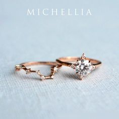 two gold rings with diamonds on them sitting next to each other in front of a light blue background