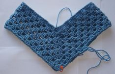 a blue crocheted piece of cloth on top of a white surface