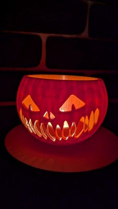 a lit up pumpkin bowl sitting on top of a table