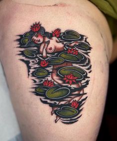 a woman's tattoo with water lilies on her thigh