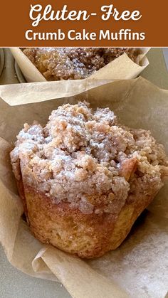 two muffins sitting on top of parchment paper with the title gluten - free crumb cake muffins