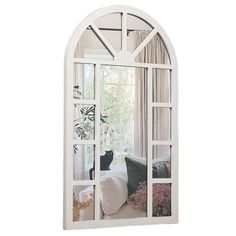 a white arched window reflecting a black cat