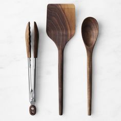 three wooden utensils are lined up next to each other