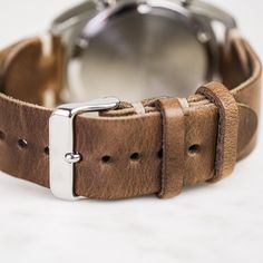 Our classic 2-piece custom watch straps feature Horween Leather in multiple color options with natural stitching. Straps feature a thumbnail style buckle and leather strap stays. As you wear your strap, you will notice how quickly it breaks in and molds to your wrist creating an incredibly comfortable fit. And with daily wear, it will deepen in color and patina becoming a piece completely unique to you.• Handmade watch band in Horween Leather• Simple stitching in Natural waxed polyester thread• Timeless Leather Strap Watch Accessories For Everyday Use, Brown Leather Strap For Round Dial Watches, Classic Leather Strap Watch Bands For Everyday Use, Classic Watch Bands With Bracelet Strap For Everyday Use, Classic Watch Bands With Waxed Finish For Everyday Use, Leather Bracelet Strap For Watch, Everyday Wear, Leather Bracelet Strap For Everyday Watch Use, Leather Bracelet Strap Watch Accessories For Everyday, Adjustable Leather Watch With Stainless Steel Clasp