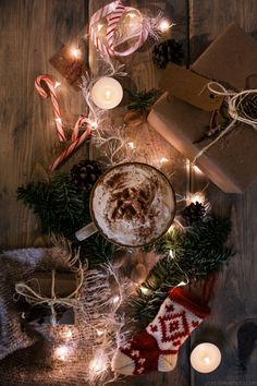 an image of a cup of hot chocolate on a table with christmas decorations and candles