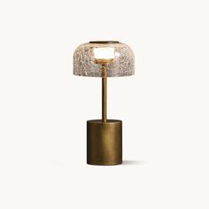 a small table lamp with a glass shade on it's base and a gold finish