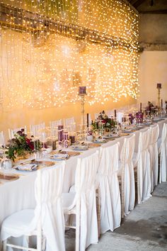 the table is set with white linens and place settings for an elegant dinner party