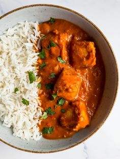 a bowl filled with rice and meat covered in sauce