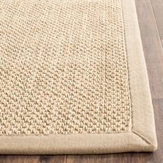 a beige rug on top of a wooden floor