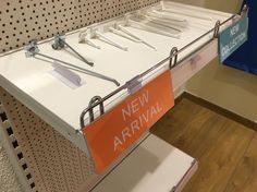 a new arrival sign is hanging on the wall next to other items in a store