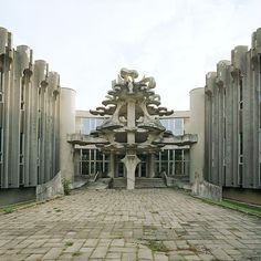 an old building with many sculptures on the front and side walls, along with brick paversed walkways