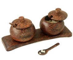 two wooden salt and pepper shakers sitting on top of a table next to a spoon