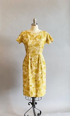 "1950s cotton sateen very fitted day dress. Ivory ground with an all over mustard brush stroke floral print. The neckline is pointed scallops. Top-stitched seams across the bodice, as well as form fitting vertical seams front and back. Cap sleeves, a V-back, with a metal zipper and hook and eye closure. Size- Small Bust - 34\" Waist - 27\" Hips - 39\" Length - 39\" Label: Janice Jr. Condition: Excellent vintage condition. All vintage is sold in \"as-is\" condition. We do our best to inspect, cor 1950s Style Yellow Dress For Vintage Fashion, Yellow 1950s Style Dress For Vintage Fashion, Yellow Fitted Dress In 1950s Style, Fitted Yellow Dress In 1950s Style, Yellow Fitted Vintage Dress 1950s Style, Fitted Mustard Cotton Dress, Mustard Fitted Cotton Dress, Fitted Vintage Mustard Dress, Fitted Yellow 1950s Dresses