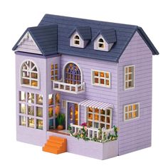 a purple doll house with lots of windows and flowers on the front window sill